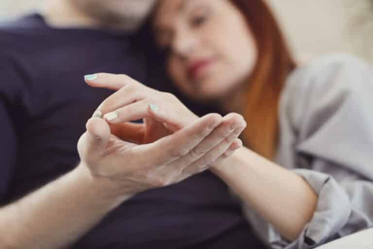 Couple in a relationship at home holding hands